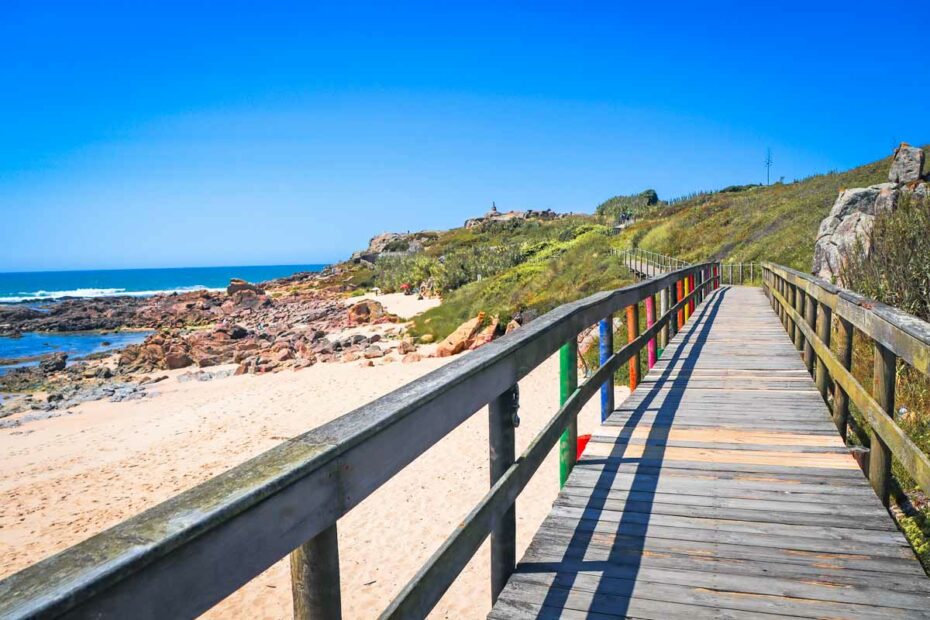 A wooden walkway along the coast with colorful planks